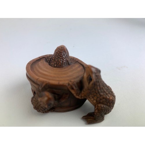 482A - Three hardwood carved frog netsukes, all with marks to base