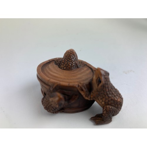 482A - Three hardwood carved frog netsukes, all with marks to base