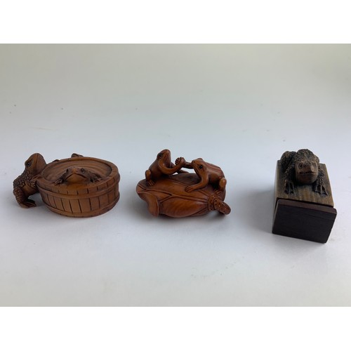 482A - Three hardwood carved frog netsukes, all with marks to base