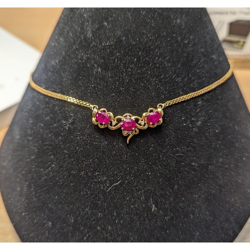 241 - 18ct gold necklace set with three rubies each measuring approx. 5mm x 4mm diameter and diamonds. Cir... 