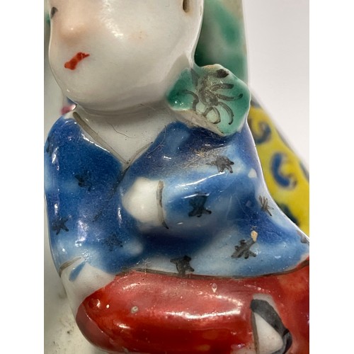 562 - A Chinese porcelain famille jaune figure of a seated Buddha, with five children, with oval seal mark... 