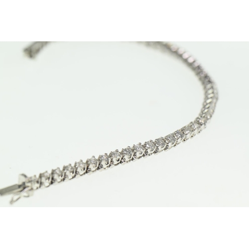 717 - 18ct white gold and diamond tennis bracelet,  claw-set with 51 round brilliant cut diamonds mea... 