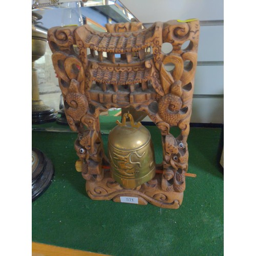 571 - Brass temple bell in carved frame. Height 36cm