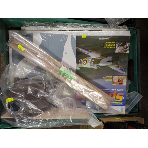 634 -  Two trays of build your own classic fighter plane, spitfire monthly RC Magazines with parts to... 