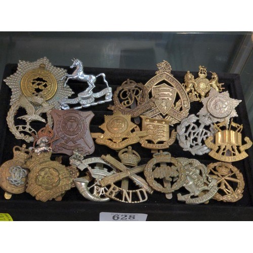 628 - Twenty-one military cap badges