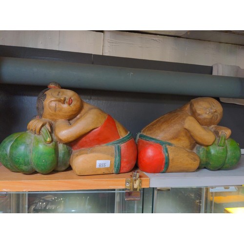 655 - Pair of Asian carved wooden figures sleeping on pumpkins, length 36cm