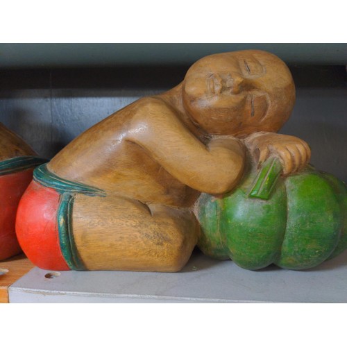 655 - Pair of Asian carved wooden figures sleeping on pumpkins, length 36cm