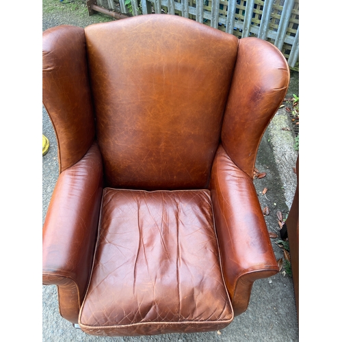 447 - Chocolate brown wing back arm chair with turned front legs and stud detail.