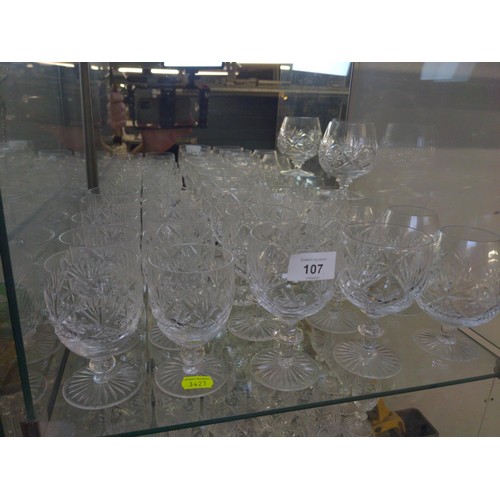 107 - Cut Glass over 3 shelves inc glasses, candlesticks & jugs etc