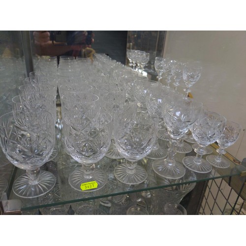 107 - Cut Glass over 3 shelves inc glasses, candlesticks & jugs etc