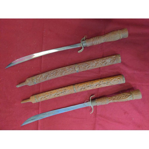 157 - Pair of Balinese style swords in carved scabbards, lengths 97 & 98.5 cms