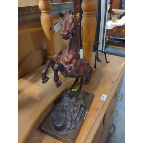 321A - A metal figure of a rearing stallion finished in bronze colour on wooden plinth. Height 38 cm