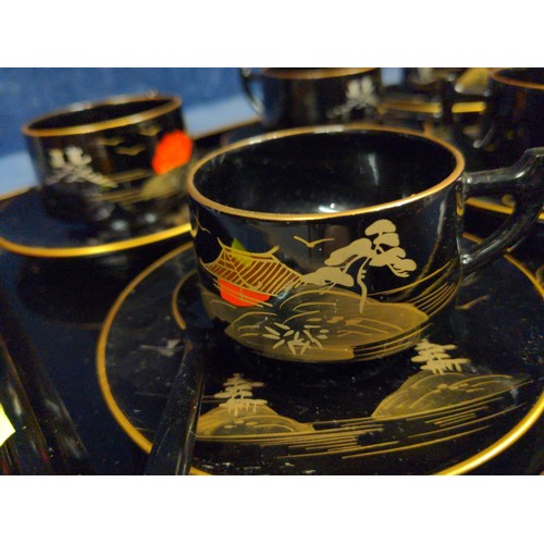 349 - Oriental black plastic coffee set with six cups, saucers, spoons and a tray.