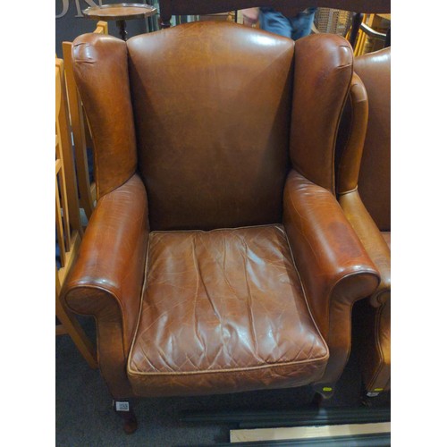 447 - Chocolate brown wing back arm chair with turned front legs and stud detail.