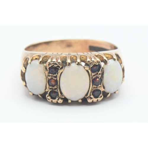 109 - 9ct gold, opal and red stone ring. Hallmarked Birmingham 1973, size Q. Gross weight 4.8g.