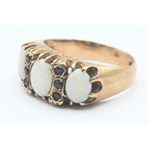 109 - 9ct gold, opal and red stone ring. Hallmarked Birmingham 1973, size Q. Gross weight 4.8g.