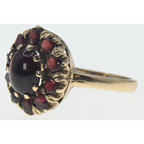 136 - 9ct gold cluster ring set with garnets. Central cabochon stone 8mm x 6mm, size R 1/2. Gross weight 4... 