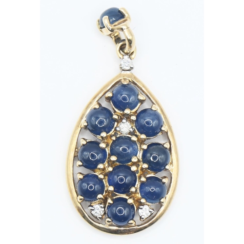 157 - Yellow metal sapphire and diamond pendant, tests positive for 14ct gold. Set with eleven cabochon sa... 