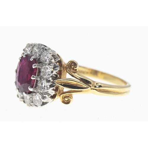 194 - 18ct gold, ruby and diamond cluster ring, the oval cut ruby displaying good colour of approximately ... 