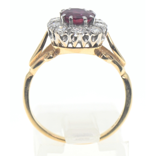 194 - 18ct gold, ruby and diamond cluster ring, the oval cut ruby displaying good colour of approximately ... 