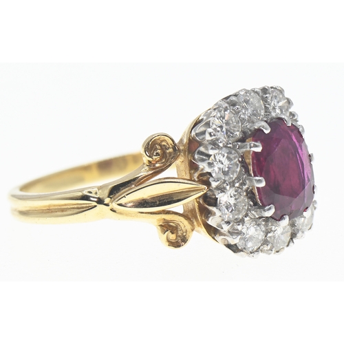 194 - 18ct gold, ruby and diamond cluster ring, the oval cut ruby displaying good colour of approximately ... 