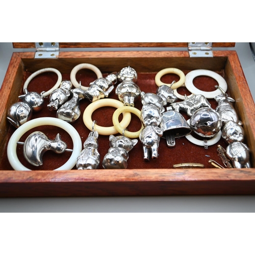 483 - Glass topped wood table top display case containing a silver Birmingham hallmarked baby rattle (miss... 