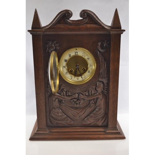 454 - A late C19th oak mantle clock carved with two seated angels, housing a French Japy Freres movement w... 