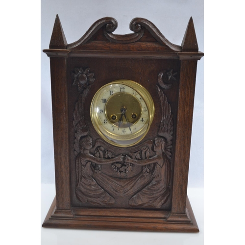 454 - A late C19th oak mantle clock carved with two seated angels, housing a French Japy Freres movement w... 