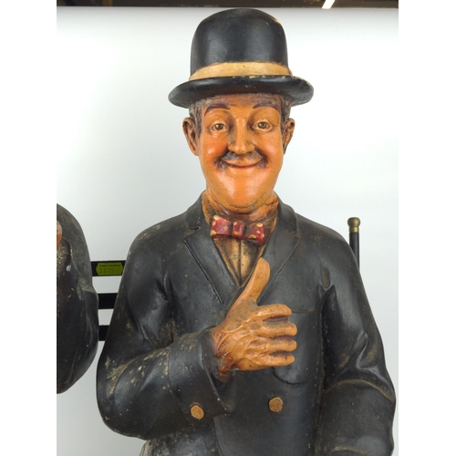 502 - Stan Laurel and Oliver Hardy resin models sat on a metal  garden bench, 57cm wide, 40cm deep and 60c... 