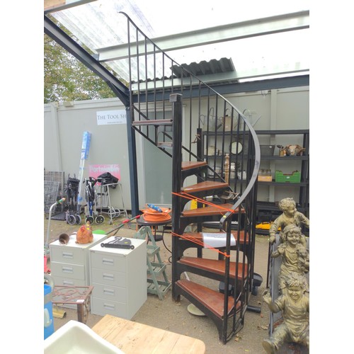 313 - Wrought Iron spiral staircase with stained wood steps in place rotation of steps, anticlockwise. Top... 