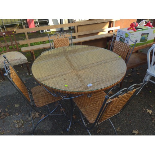 106 - Metal and rattan circular garden table and four folding chairs, glass top to table. D101cm x H76cm