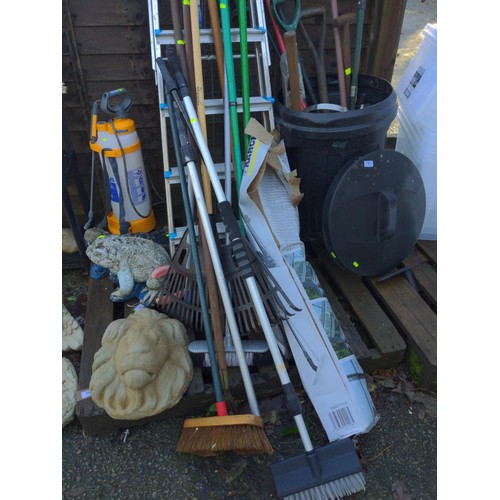 61 - Black plastic bin with mostly long handled tools.