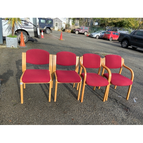 119 - Four red upholstered modern office chairs.