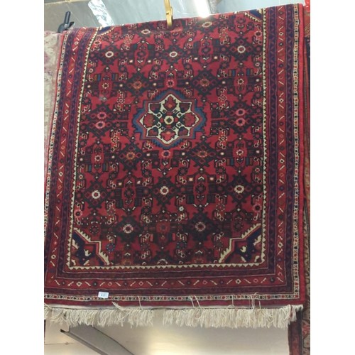 817 - Geometric patterned rug with central medallion. W104cm