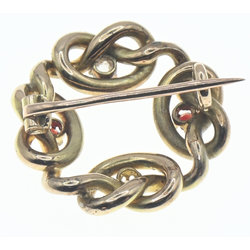 29 - 15ct gold knot brooch, set with two diamonds and two red stones, diameter 25mm, gross weight 5.3 gra... 