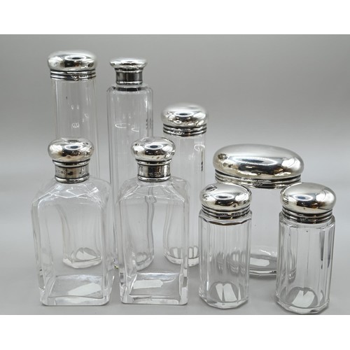 167 - Set of six silver lidded glass vanity bottles, maker's mark rubbed, London 1911, together with a sim... 