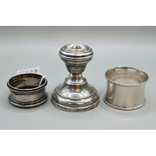 184 - Two silver napkin rings and silver candlestick (weighted), various Birmingham makers and dates