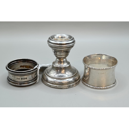 184 - Two silver napkin rings and silver candlestick (weighted), various Birmingham makers and dates