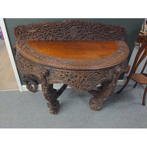 Burmese hardwood demi lune console or hall table carved with leopards, exotic birds and foliage on leopard head legs and dolphin feet, W130 x D58 x H75cm (not including back frieze) All carving and panels intact, some small scratches and split to top surface