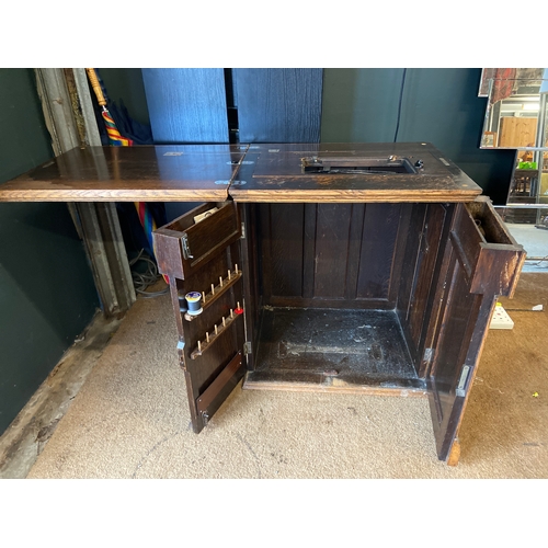 1176 - Vintage sewing table with flip top working area, two cupboard doors and some items of sewing equipme... 