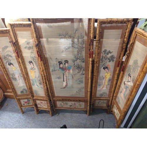 956 - Four panel bamboo screen painted with ladies. Length when open, 140cm x height 121cm.