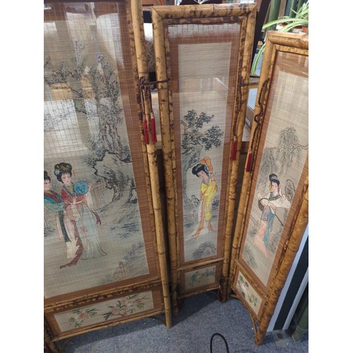 956 - Four panel bamboo screen painted with ladies. Length when open, 140cm x height 121cm.