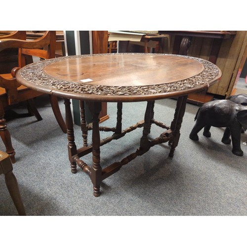 653 - Carved oak two leaf folding oval table. W113 D78 H53 cm approx