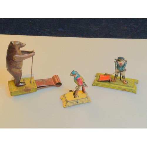 457B - Three tin penny toys; jumping bear, figure (part missing) and rocking parrot.