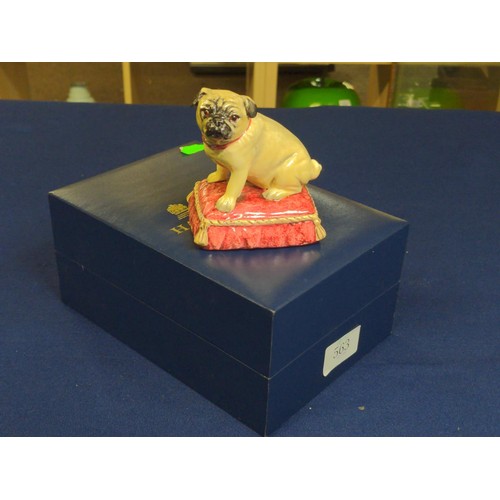 563 - Halcyon Days porcelain pug, modelled seated on a cushion, height 9.2cm, with box