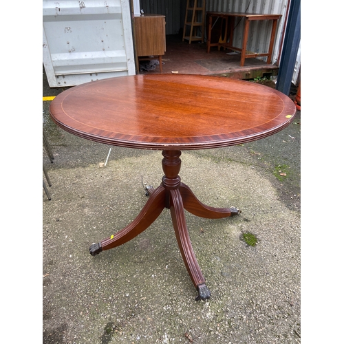 85 - Modern mahogany reproduction circular tilt top table with central pedestal and four claw feet . Dia ... 