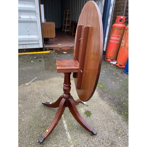 85 - Modern mahogany reproduction circular tilt top table with central pedestal and four claw feet . Dia ... 