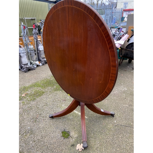 85 - Modern mahogany reproduction circular tilt top table with central pedestal and four claw feet . Dia ... 