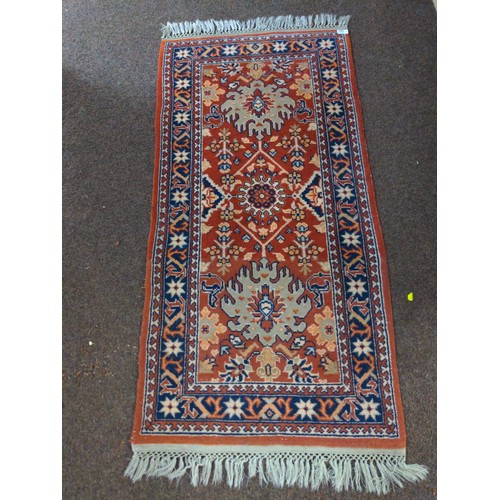 586 - Small rug in brick red, navy & gray. 135cm long x 68cm wide. 