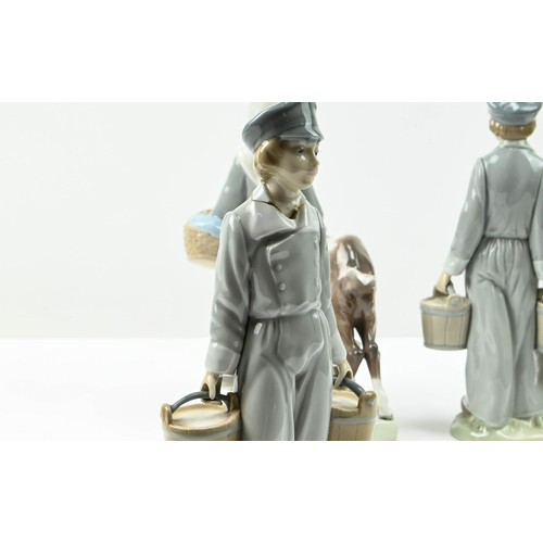 307 - Three Lladro figures including two Dutch boys with pails (one with repair to neck) and a girl with g... 